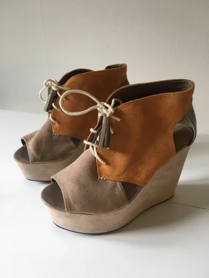 Beige platåsko - Beige platåsko med snörning. Öppen tå. Aldrig använda. 