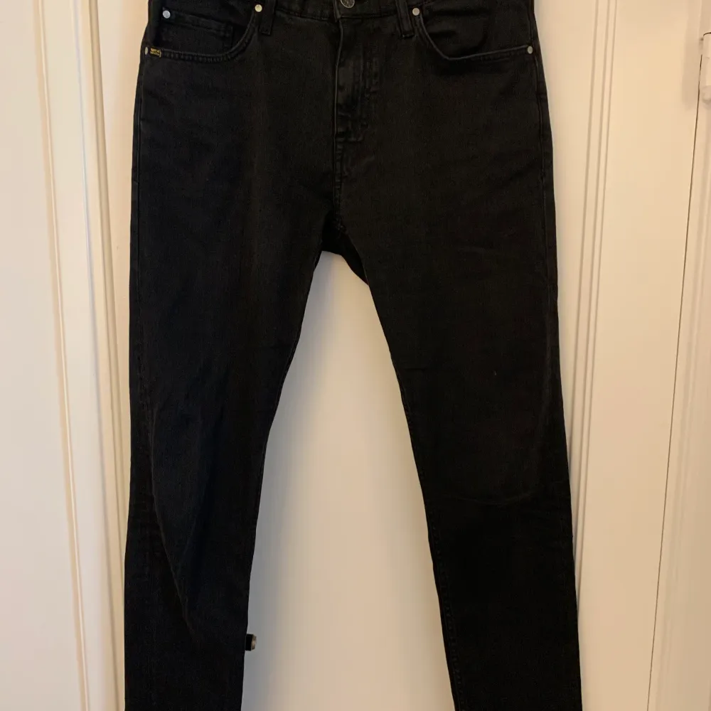 Svarta smala jeans med stretch förr herr, från Tiger of Sweden. Knappt använda men de har varit insydda i midjan, se bilder. Modell: Pistolero, storlek: 31/32. 98% bomull, 2% elastan.   Hämtas vid Nobeltorget eller postas mot frakt på 70 kr.. Jeans & Byxor.