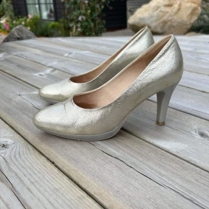 Guldiga pumps - Snygga guld/ metallic pumps med silvrig klack.  Använda 1 gång på ett bröllop  Nypris 999kr 