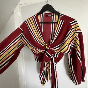 Blus Bik Bok - En croppad röd/randig blus från Bik Bok. Fint skick och i strl XS. 
