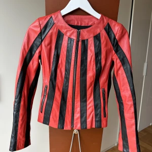 Röd / svart skinnjacka  - Rödsvart randig skinnjacka, som tyvärr är för liten :’( Storlek S och i superbra skick! 