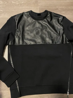 Hugo Boss tröja  - En tröja från Hugo Boss och kollektionen dem hade med AJBXNG. I färgen svart och storleken M. Den är bara använd 2 gånger och är därför i mycket bra skick.  Köpt för 1499kr. Säljer den för 400kr.