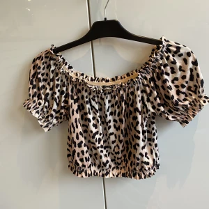 Topp  - Leopard topp som kan dras ner på axlarna 