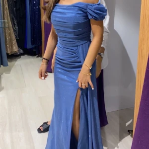 Ljusblå klänning  - Säljer min klänning som jag har bara endast använt ett tillfälle. Jätte fin färg och det är glittrig skön material, det är perfekt till bröllopet och bal. 