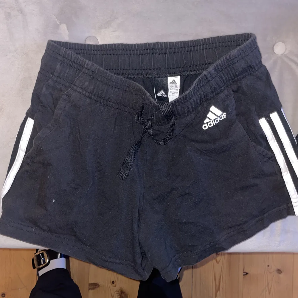 SVarta shorts från adidas i storlek XS. de är i bra skick och har knappt använts. fickor på sidorna. Så bra kvalitet och väldigt sköna. Svarta med vita ränder på sidan. Snygga och bekväma. Passar till allt Du kan träna i de men även använda de till vardag. Shorts.