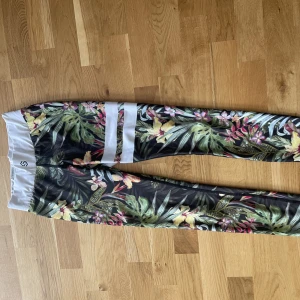 Stronger träningsbyxor  - Stronger träningsbyxor i coolt mönster. Försmå för mig tyvärr men nycker bra skick.🧡💚💙