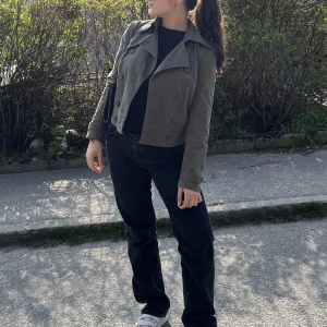 Militärgrön kort trenchcoat - Hej jag säljer denna coola militärgrönajacka som är från Maria Westerlund som är väldigt snygg och passar perfekt nu till hösten. 