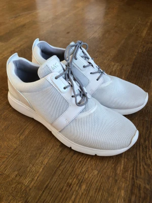 Michael Kors vita sneakers  - Michael Kors sneakers helvita, mesch/läderdetaljer. Stl 40.5  Använd inomhus 2-3 gånger. Inget slitage, se bilder på sulan. 