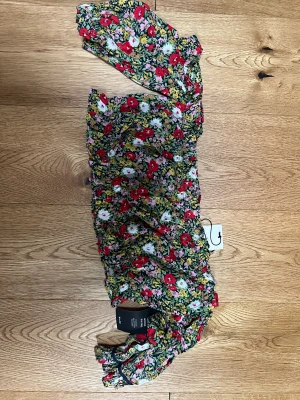 Blommig off sholder tröja  - Helt oanvänd kort off-sholder blus från NA-KD. 