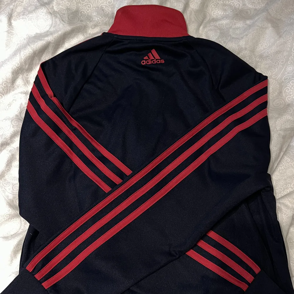 Adidas Track Top i färgen mörkblå och röd. Köpt i Adidas butik på Freeport för ca ett år sedan, i nypris 400. Storlek S (34-36) Funkar för både tjej och kille. Lite kort i modellen. Använd 2-3 gånger så i princip ny. Inga skador eller liknande.. Hoodies.