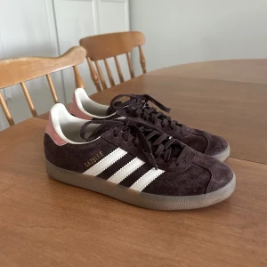 Adidas Gazelle  - Skitsnygga och unika adidas gazelle. De är i en brun/lila färg med ljusrosa detaljer och ljusbrun sula. Använd två gånger pga fel storlek :) pris går att diskutera vid snabbbaffär 