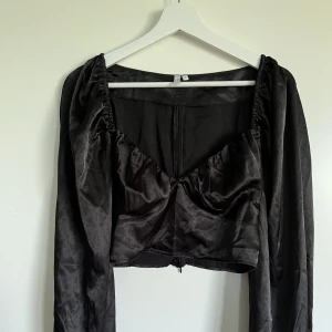 Glansig festtopp från NELLY  - En ursnygg festtopp från NELLY, aldrig använd men prislapp borta. Tänkte ha den men ångrade mig, satt inte toppen på mig. 