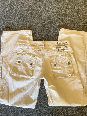 Byxor med vida ben - Lågmidjade gräddvita byxor med vida ben, luftigt material och snygga detaljer. Perfekt för sommaren. Mått kan ges privat!
