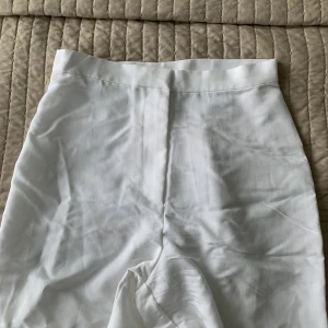 Vita kostymbyxor i svalt material  - Storlek 36  Supersnygga på, sitter bra över rumpa och lår.   Säljes pga används aldrig.  