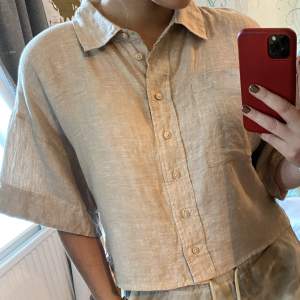 En kortare beige skjorta, 100% linne, storlek 36, luftig och bekväm, från 2020, köptes för ca 200kr, nyskick då den basically är oanvänd