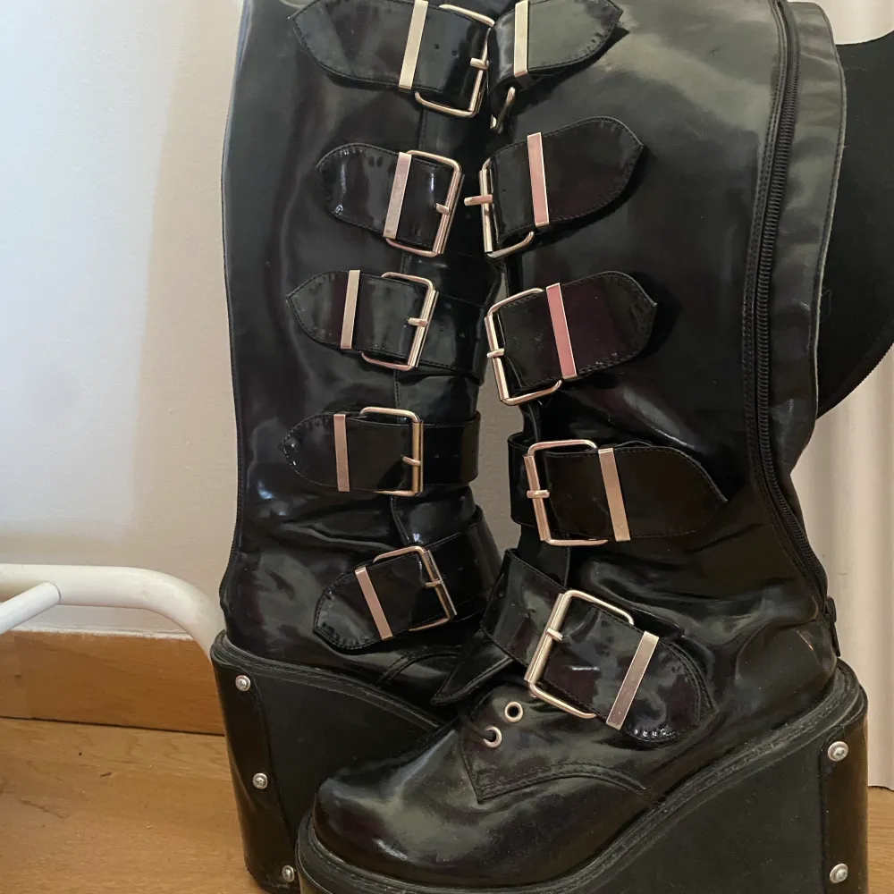 Äkta demonia boots från 90 talet. Lite dammiga då de bara stått i flera år, men jättebra kvalitet. Kommer också med flera olika detaljer man kan byta på plattformsdelen , som nitar och eldsflammor. Storlek står inte men passar mig som har 37/38!. Skor.