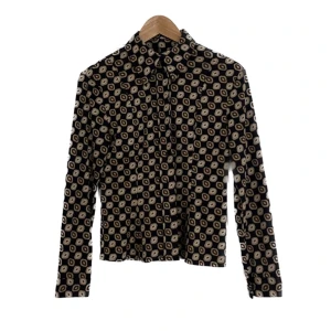 Skjorta i retromönster - Skjorta från humana i polyester, formar sig fint på kroppen. Använder inte länge men har varit väldigt rolig att stylea i retroinspirerade outfits. Finns ingen storlekslapp men passar bäst en S/M