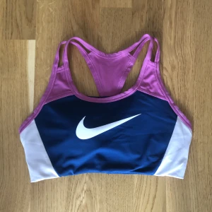 Sport-bh Nike - En färgglad bekväm sport-bh från Nike som jag inte använder då den är för liten på mig. Den har en tunnare vaddering som sitter fast vilket gör att den inte åker ut i tvätten! Storlek S