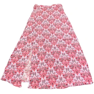 Mönstrad Långkjol - Varan går att köpa direkt på vår hemsida, ettmarke.se Färg: Vit, lila, röd, brun & rosa. Modell: Långkjol. Storlek: XS enligt lapp. Kan passa större och mindre storlekar pga resårbandet runt halva midjan. Midja platt rakt över: 33 cm. Totallängd 85cm. 