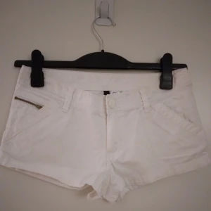 Vita korta shorts med flera fickor, Strlk 36 / XS-SMALL.  - Vita korta shorts i bra skick, Strlk 36 / XS-S. Flera fickor. Stängs med dragkedja och knapp. Material: Kraftigare bomullstyg.  Midjemått på dessa är ca cm. Säljer även likadana fast svarta, samt ett par korallfärgade - se mina övriga annonser.  