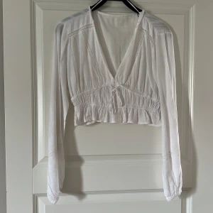 Blus - En vit blus med broderade detaljer från pull and bear.