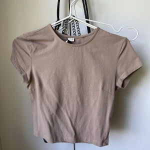 Beige topp - Beige croppad T-shirt från Nelly i storlek Xs
