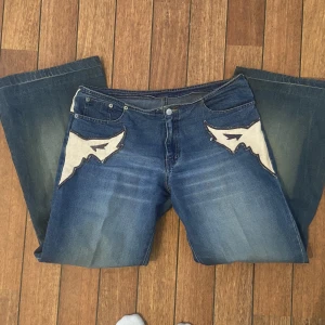 Skitsnygga jeans - Låg midja och utsvängda där nere med en trampstamp på rumpan.