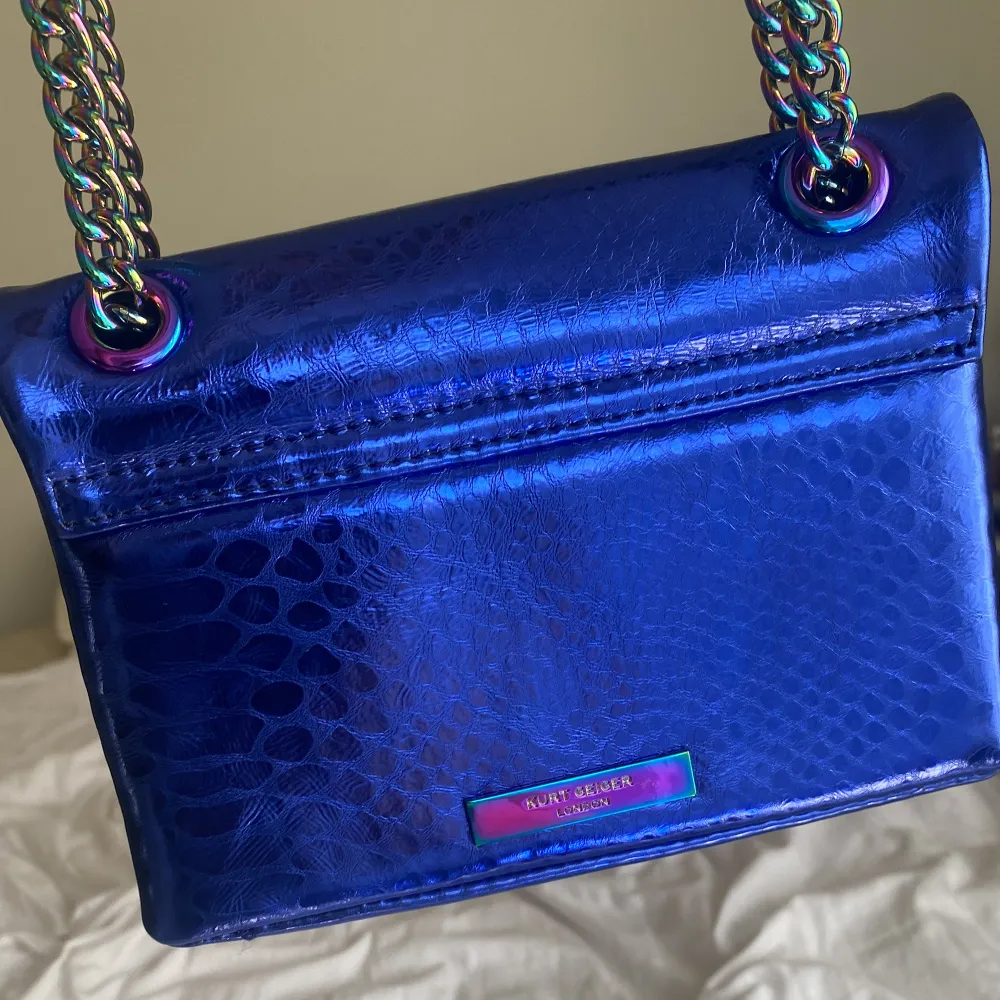 En blå väska från kurt geiger i den lilla modellen. Väskan är i väldigt bra skicka och har använt den ett få antal gånger. . Väskor.