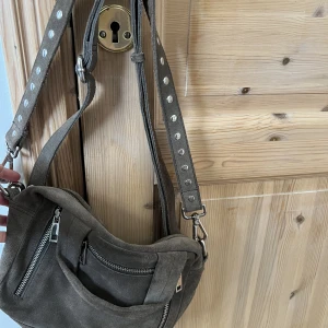 Nunoo väska - Hej! Jag säljer min gråa nunoo väska i mocka. Den är väldigt rymlig och går inte att köpa längre💘tror den är köpt för runt 1500-2000