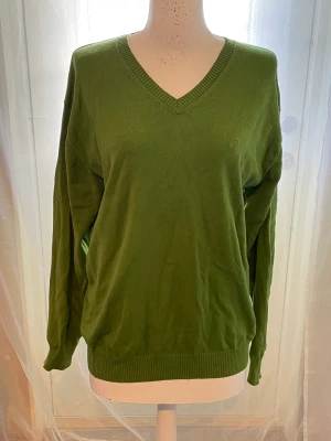 Grön urringad tjocktröja  - Broderi på framsidan och urringad.