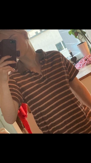 T-shirt med krage - Brun- gul och rosa randig t-shirt med krage. Använd men väl omhändertagen :)