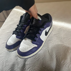Air Jordan 1 low court purple - Äkta Jordans i hyfsat skick, creasade samt liten skada längst fram på högerskon. Bara att skriva, vid frågor elr mer bilder på skorna. 