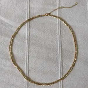 Skitsnyggt guldfärgat halsband. Kedja i metall med förlängning. Den guldiga färgen skiftar lite grann. Ca 47 + 7.5 cm långt. Kan skickas med ett frimärke (18 kr).