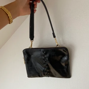 Svart väska - Supersnygg och elegant svart väska som passar perfekt för att ha med på fest, när man är ute på stan eller om man ska ut på middag!🤩 Man kan byta band på väskan ifall man vill det.