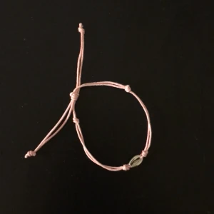 Rosa armband - Säljer detta handgjorda rosa armband med en silvrig snäcka, justerbar storlek💕
