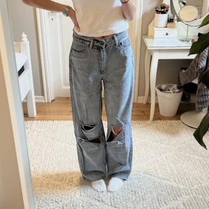 Blåa oversized jeans med slitningar  - Blåa oversized jeans med slitningar från Boohoo. Jag är 173cm. 