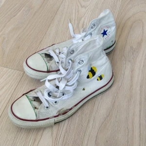 Converse med humlor på - Väl andvända converse. De är limmade och ihopsydda men går helt att använda. Därav priset. Annars är de super gulliga med humlor, blommor och måln på.