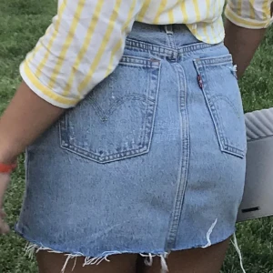 LEVIS KJOL W 24 - Kort Levi’s kjol w 24 med slitningar. 5 knappar varav 4 gömda.