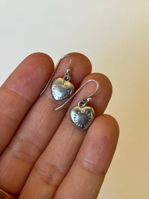 Silverfärgade örhängen från Marc Jacobs  - Örhängen från Marc Jacobs i silverfärg som är något mörkare i färgen.   Fantastiska men kommer tyvärr inte till användning hos mig. Hoppas dom får komma till någon som använder dom mer 💖