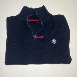 Henry Lloyd half zip - Henry Lloyd half zip stickad tröja. Otroligt fint kvalite och design. Har britiska flaggan på axeln. Är i bra, skulle säga minst 7/10. Nypris ca: hittar inte den men drygt 1000kr