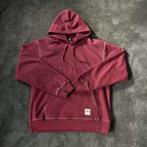 Säljer denna skit feta stussy workwear hoodie så den är riktigt bra material, i färgen ”berry”. Använd 2 gånger sparsamt utomhus. Har alla tags kvar och den är köpt från SNS för 1650 Storlek L