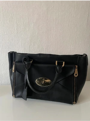 Mulberry handväska - Fin Mulberry väska i äkta läder. Den är välanvänd, se bilder. Axelrem tillkommer. Tyvärr så kommer den inte längre till någon snvändning.  Mått bredd 27-37cm, djup 10cm, höjd 20cm.  Se mina gärna mina övriga annonser 🌸