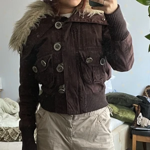 Brun vårjacka  - Unik vårjacka med pälskrage! Pälskragen går att ta av med tryckknappar! Dessvärre är fuskpälsen missfärgad, jag kan skicka bild om så önskas ☀️