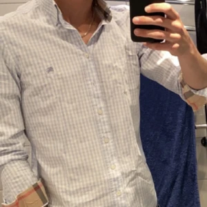 Burberry Skjorta - Tjenare! Säljer nu min burberry skjorta. Passar as bra med sina ljusafärger nu på sommaren med ett par jeans eller linnebyxor. Skicket är 9/10 och den är självklart äkta, sitter som M/L. Vid funderingar eller fler bilder är det bara att skriva!