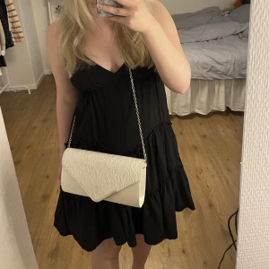 Vit axelremsväska  - En mycket fin och lyxig axelremsväska som endast har använts vid ett tillfälle, bal. Väskan har några tecken på användning, skriv för mer info, men är i väldigt fint skick! Perfekt till student eller skolavslutning. 