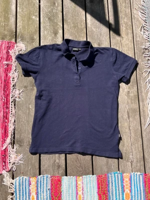 Piké CRW  - Ridkortärmad med krage och knappar upptill. Knappt använd och i nyskick. Nypris: 249kr