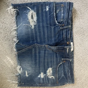 Lågmidjad Jeanskjol - As snygg kjol från Abercrombie & Fitch! Snygg passform med slitningar!  Midja rakt över 45 cm Längd på kjolen cirka 32 cm