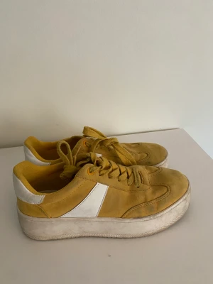 Sneakers gula - Gula sneakers från Duffy i mocka. Har tappat färgen något och är lite nedgångna inuti vid trampdynan. I övrigt okej. Skicka för mer info och bilder