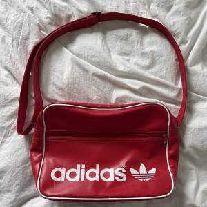 Adidas retro axelremsväska i röd. Väskan har några fläckar men i övrigt i bra skick. 