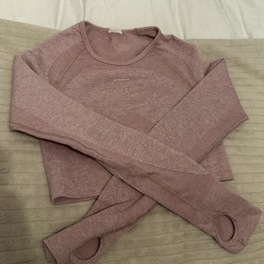 Säljer min rosa Gymshark long sleeve topp, precis som på bilden. Inga defekter förutom att jag klippt av lappen vid nacken då den störde vid träning. Använd några ggr. Säljes då den inte används längre💗. Toppar.